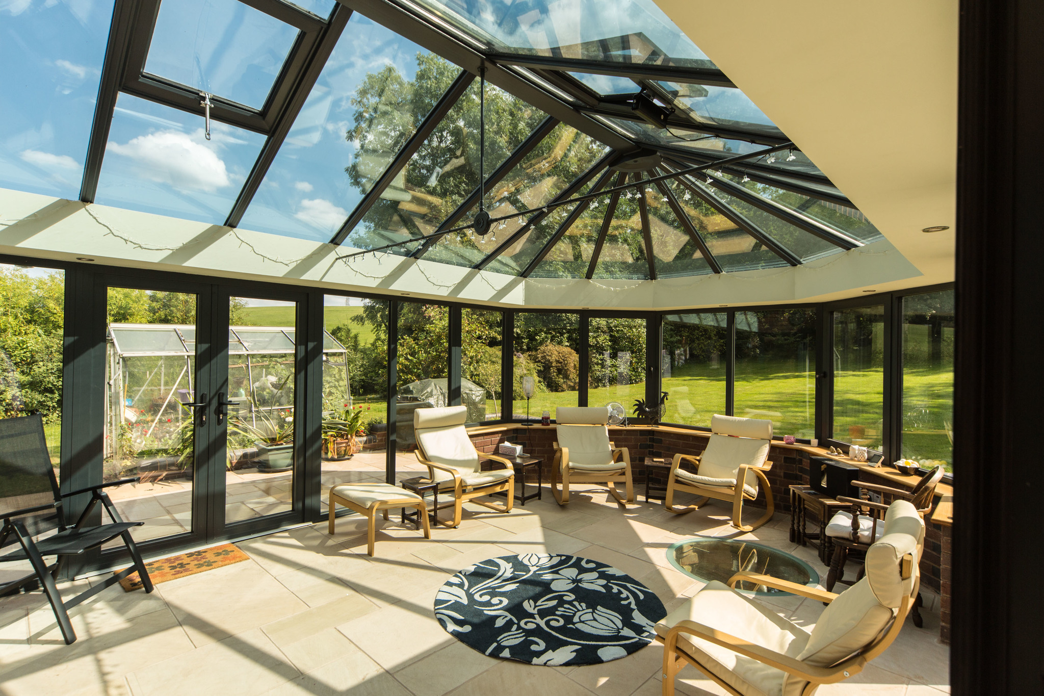 A {large} conservatory with a glass roof offering {stunning views} in Tetbury.