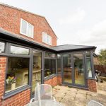 A conservatory in a home with a table and chairs available for use as a Performance Conservatories in Tetbury.