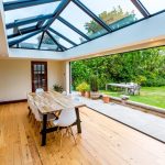 A room with a wooden floor and a glass roof offers a unique ambiance in an urban setting.